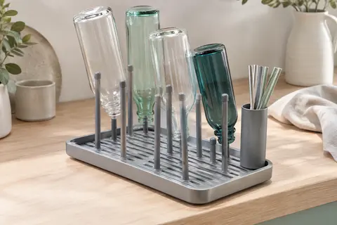 Égouttoir gris à cadre en aluminium avec bords relevés, plaque d’égouttement et porte-pailles vertical.