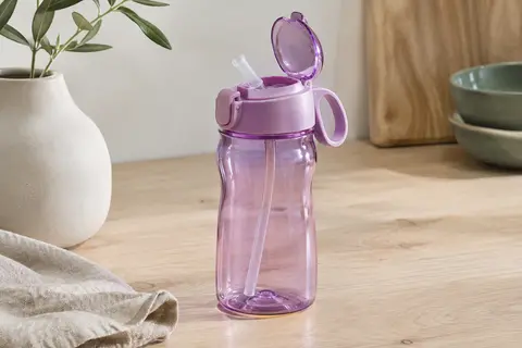 Gourde enfant en Tritan transparent, teinte orchidée, avec paille relevée et boucle de transport intégrée.